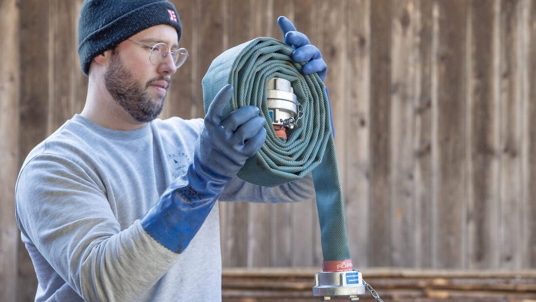 Fachmann: Jon Fritz rollt nach der Wasserlieferung einen Schlauch zusammen.