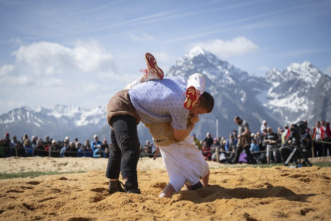 Kopfüber: König Orlik steckt Patrik Feldmann ins Sägemehl – vor der Bergkulisse. (Bilder: Gian Ehrenzeller / Keystone)