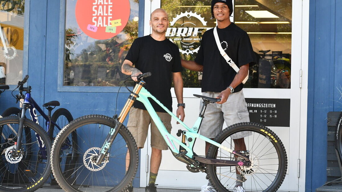«Weihnachten» im August: Tyrik Springer aus Tobago (rechts) hat von Rodrigo Lopez Durante vom Drift Bike-Shop in Mels ein neues Downhillbike erhalten. (Bild: Reto Voneschen)