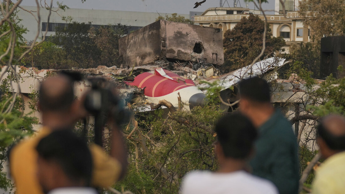 ARCHIV - Menschen betrachten die Wrackteile des abgestürzten Flugzeugs von Air India. Foto: Rafiq Maqbool/AP/dpa 20250712030405671.jpg