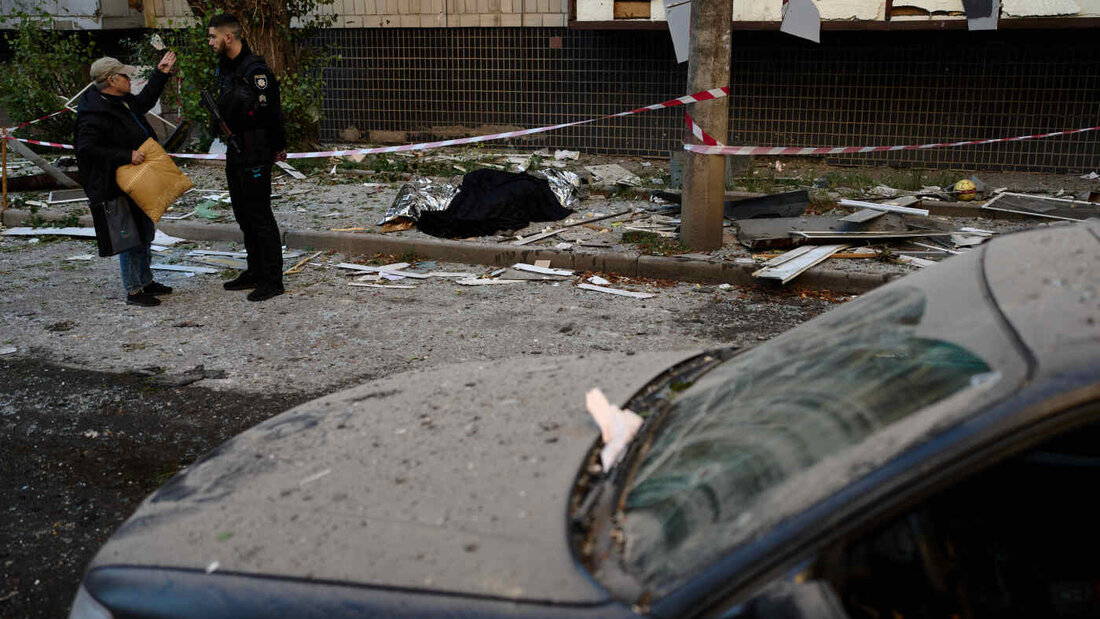 dpatopbilder - Ein Polizist spricht mit einem Anwohner neben den Leichen zweier Menschen, die bei einem nächtlichen russischen Angriff ums Leben gekommen sind. Foto: Francisco Seco/AP/dpa 20260820085418987.jpg