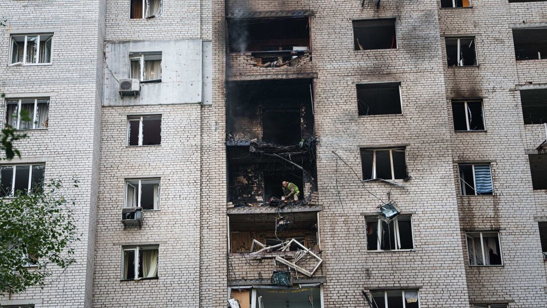 Ein Polizeibeamter wirft vom Balkon eines Hauses, das bei einem russischen Angriff auf ein Wohnviertel in Kiew beschädigt wurde, Trümmerteile einer «Shahed»-Drohne hinunter. Foto: Evgeniy Maloletka/AP/dpa 20260925152505748.jpg