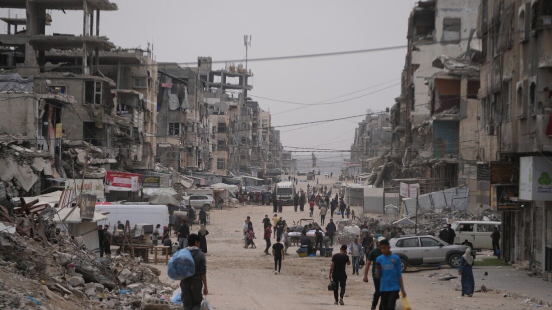 ARCHIV - Palästinenser gehen in der Stadt Gaza eine Straße entlang, die von zerstörten Gebäuden umgeben ist. Foto: Abdel Kareem Hana/AP/dpa/Archivbild 20260601182919385.jpg