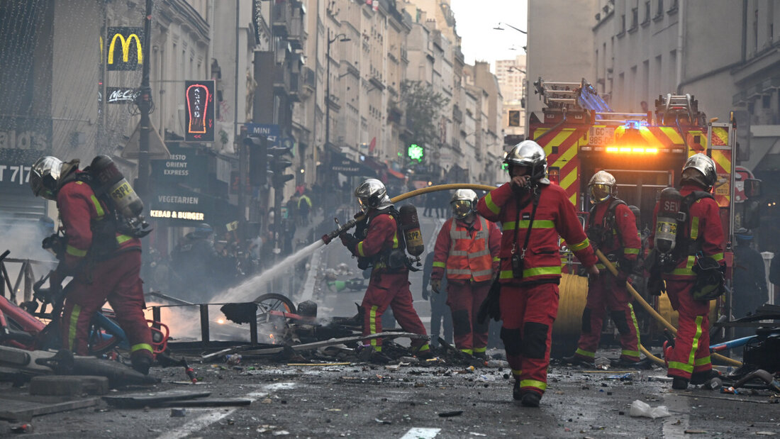 dpatopbilder - Feuerwehrleute löschen einen Brand während einer Demonstration gegen steigende Lebenshaltungskosten, bei der sich die Teilnehmer den Forderungen der Studenten anschlossen haben. Foto: Emma Da Silva/AP/dpa 20261018092406788.jpg