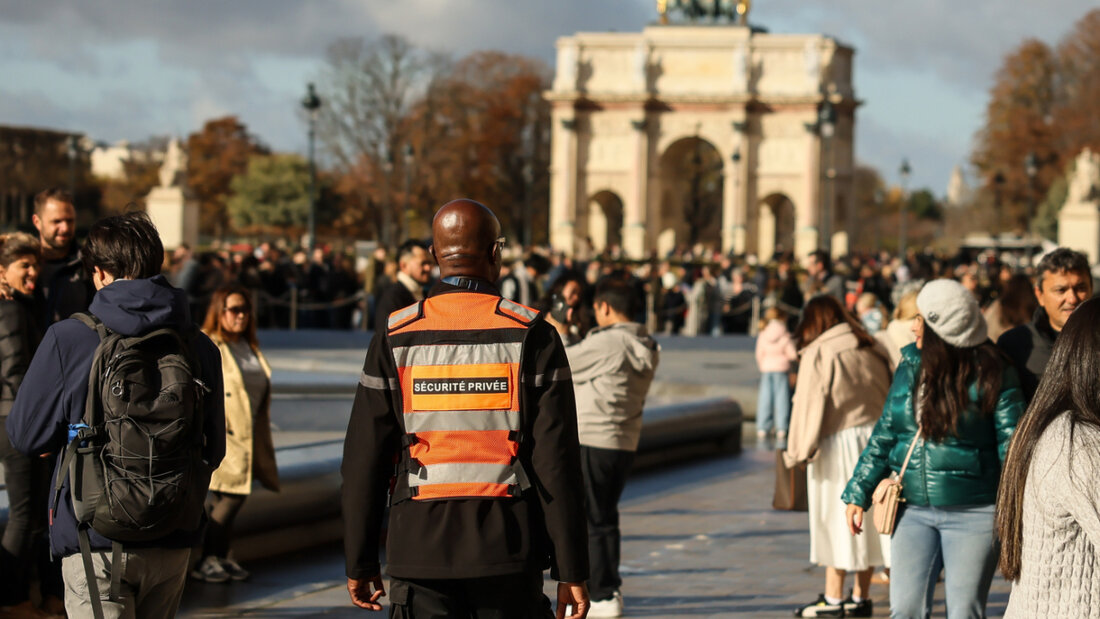 Ein Mitarbeiter eines privaten Sicherheitsdienstes (M) und Besucher gehen durch den Innenhof des Louvre-Museums. Eine Woche nach dem spektakulären Kunstraub im Pariser Louvre hat es zwei Festnahmen gegeben. Das bestätigte die Pariser Staatsanwaltschaft auf Anfrage der Deutschen Presse-Agentur, nachdem zuvor französische Medien darüber berichtet hatten. Foto: Thomas Padilla/AP/dpa 20251027054409260.jpg