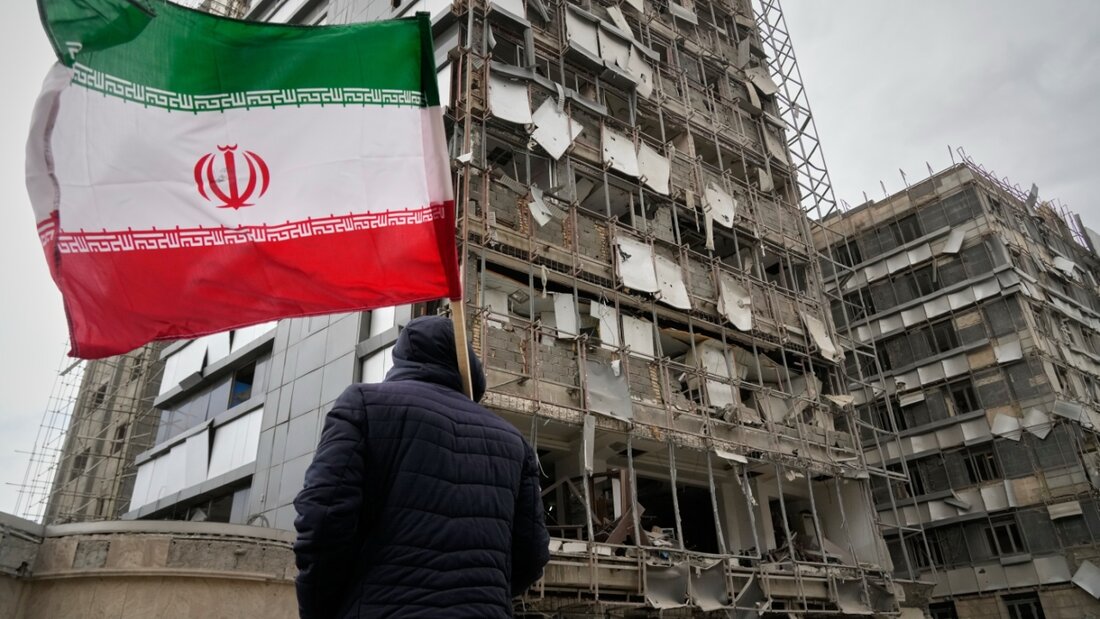 Ein Mann hält eine iranische Fahne neben dem beschädigten Gandhi-Krankenhaus, das am Sonntag während eines Angriffs auf einen Fernsehturm des staatlichen Fernsehens getroffen wurde. Foto: Vahid Salemi/AP/dpa 20260303133225385.jpg