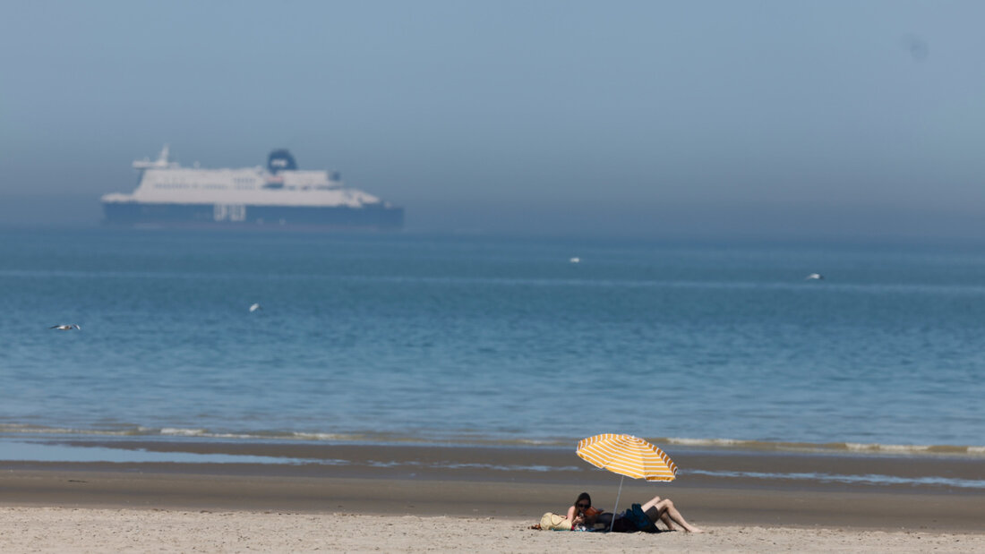 Menschen unter einem Sonnenschirm am Strand von Gravelines. Foto: Jean-Francois Badias/AP/dpa/Archivbild 20260621144257224.jpg