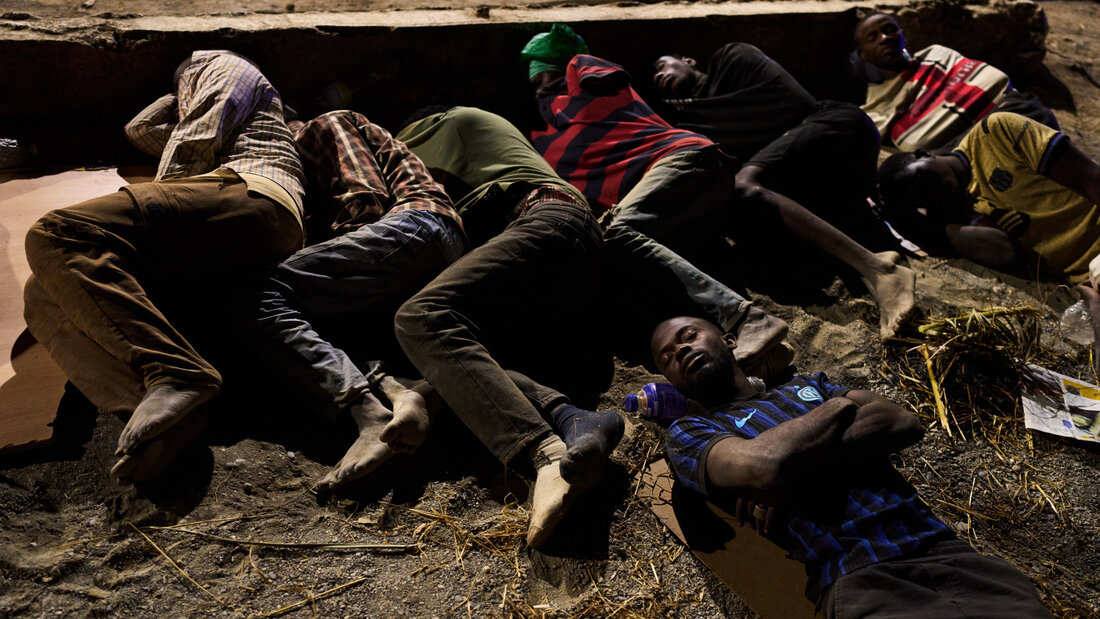dpatopbilder - Migranten, die aus Marokko nach Spanien eingereist sind, schlafen an einem Strand in der spanischen Exklave Ceuta. Foto: Bernat Armangue/AP/dpa 20260804152330964.jpg