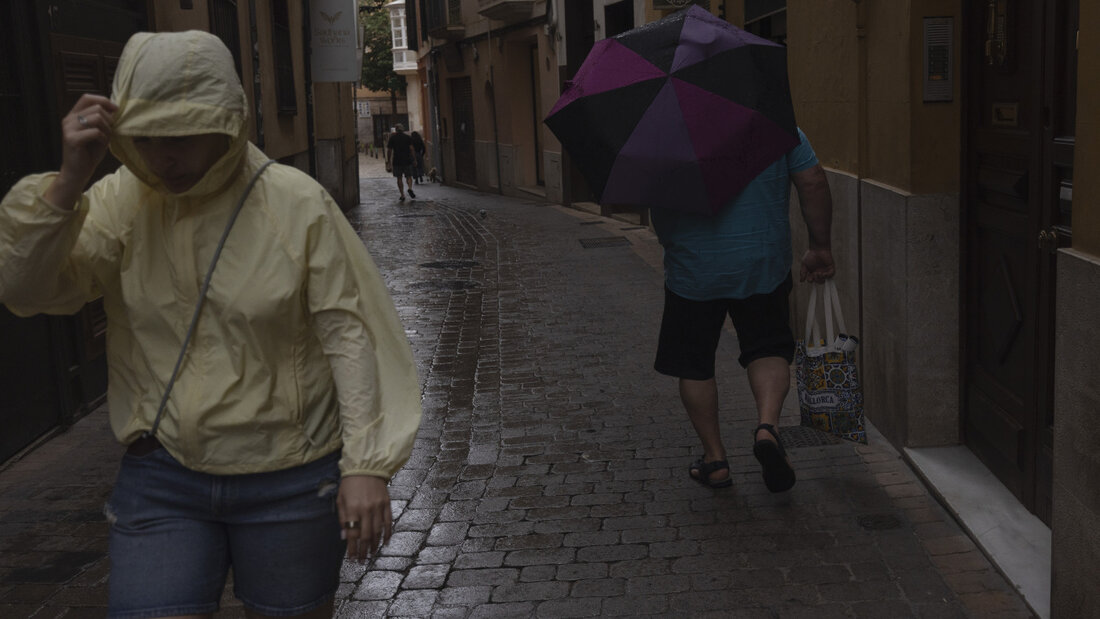 dpatopbilder - Menschen gehen im Regen durch die Innenstadt von Palma. Der Sturm "Adam" zieht gerade über die Insel hinweg, und für die Bevölkerung wurde eine rote Warnstufe ausgerufen. Foto: Clara Margais/dpa 20261019121934604.jpg