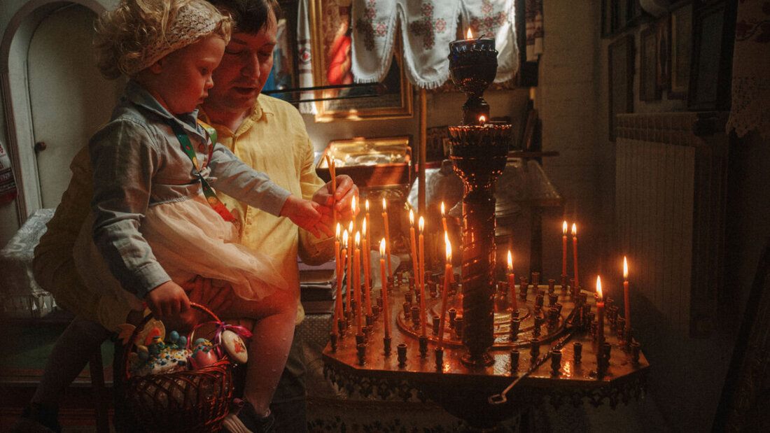 Ein Vater hilft seiner Tochter beim Anzünden einer Kerze während der orthodoxen Osterfeier in der St. Johannes Theologen Kirche der Orthodoxen Kirche der Ukraine in Charkiw. Am Wochenende sollen es in der Ukraine eine Waffenruhe geben, damit die Menschen Ostern feiern können. Foto: George Ivanchenko/AP/dpa 20260411050756042.jpg