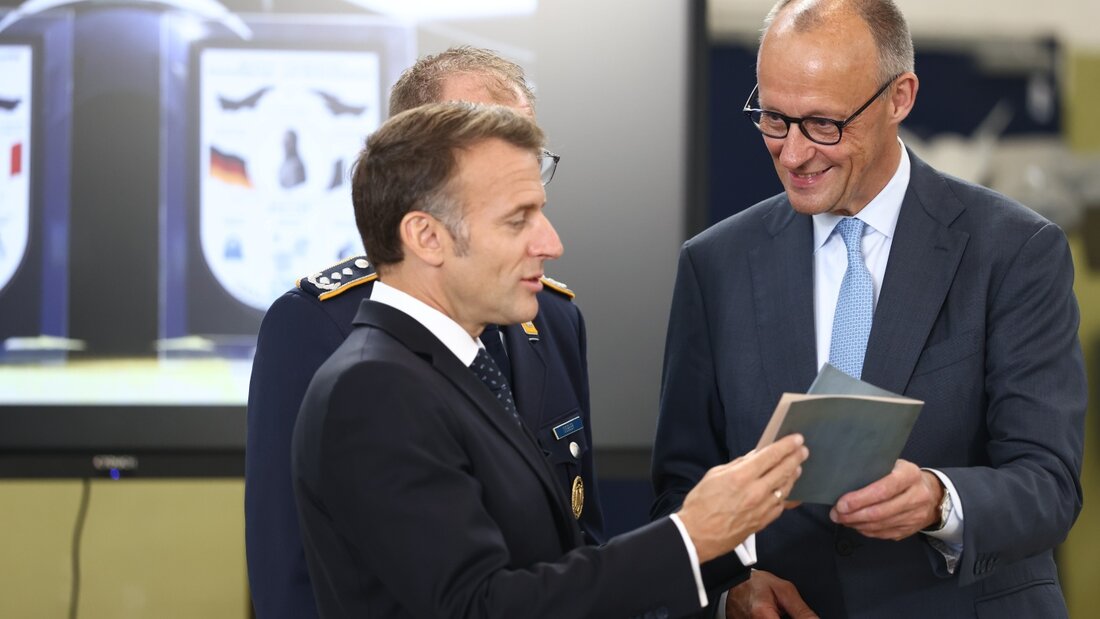 Emmanuel Macron, Präsident von Frankreich und Bundeskanzler Friedrich Merz (r, CDU) halten ein historisches Buch zur Fliegerei in ihren Händen. Foto: Rolf Vennenbernd/dpa 20260717105826809.jpg