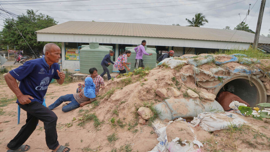 dpatopbilder - Freiwillige der Dorfsicherheit und Anwohner rennen in einen Schutzraum, als Explosionen in der thailändischen Provinz Buriram nach dem erneuten Grenzkonflikt zwischen Thailand und Kambodscha zu nah sind. Foto: Sakchai Lalit/AP/dpa 20251214064015465.jpg