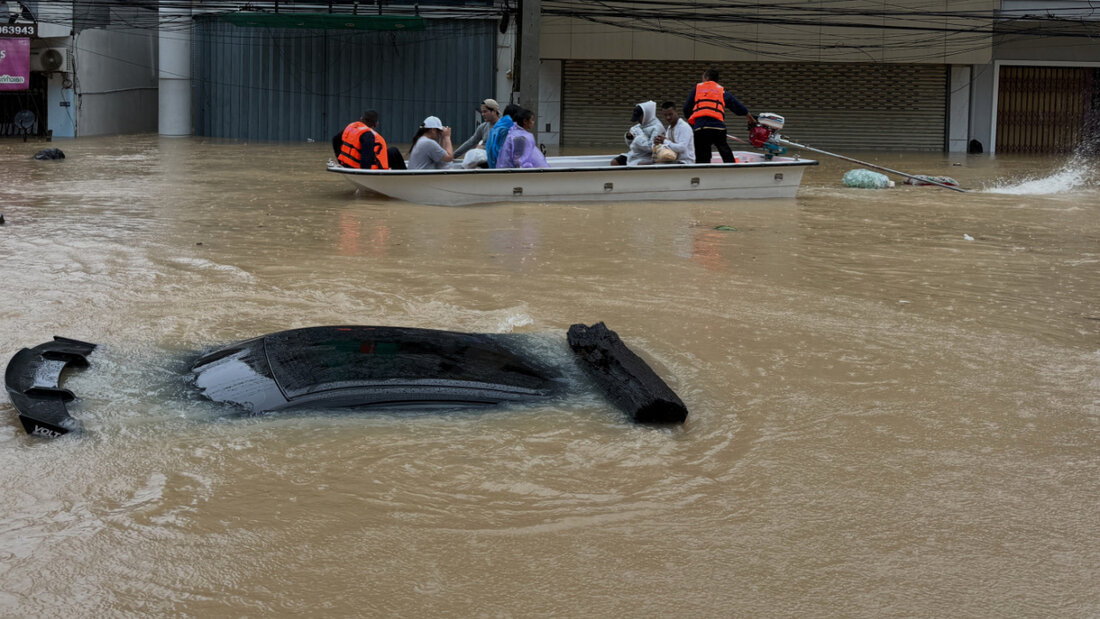 Thailändische Rettungskräfte bewegen sich auf einem Boot an einem Auto vorbei, das in der südthailändischen Provinz Songkhla in den Fluten versunken ist. Foto: Uncredited/AP/dpa 20251125094431514.jpg