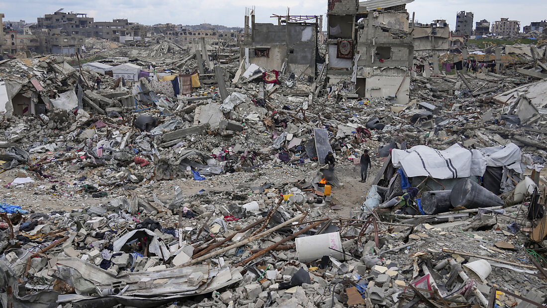 ARCHIV - Menschen gehen inmitten der Trümmer von Häusern, die durch die Luft- und Bodenoffensive der israelischen Armee gegen die Hamas zerstört wurden, im nördlichen Gazastreifen. Foto: Abdel Kareem Hana/AP/dpa/Archivbild 20250406205519820.jpg