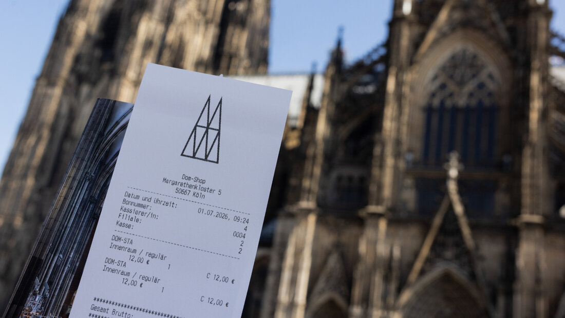 Eine Touristin zeigt ihr Ticket vor dem Kölner Dom. Der Eintritt in den Kölner Dom kostet ab dem 1. Juli zwölf Euro für Besucher. Betende sollen in einen bestimmten Bereich weiterhin kostenlos Zutritt erhalten. Foto: Rolf Vennenbernd/dpa 20260701101911568.jpg