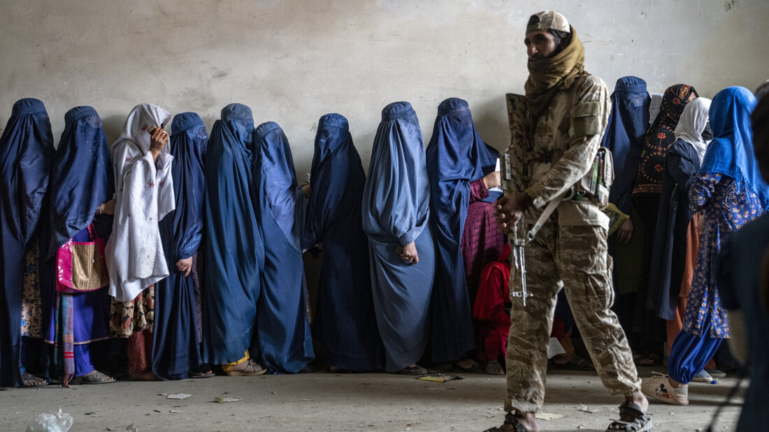 ARCHIV - Ein Taliban-Kämpfer steht Wache, während Frauen in Kabul darauf warten, Lebensmittelrationen zu erhalten, die von einer humanitären Hilfsgruppe verteilt werden. Foto: Ebrahim Noroozi/AP/dpa 20260710104151971.jpg