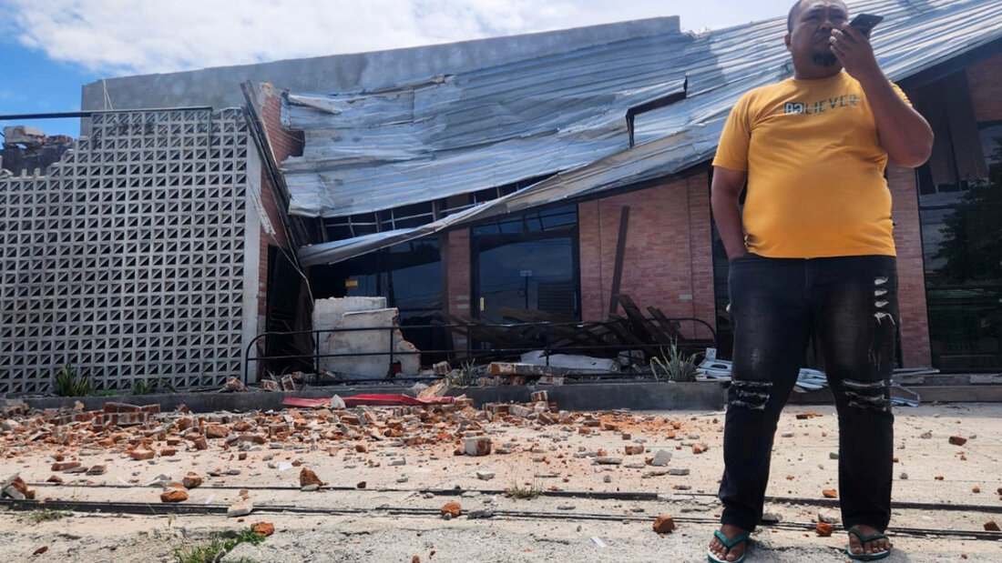 dpatopbilder - Ein Mann telefoniert mit seinem Handy in der Nähe eines durch ein Erdbeben beschädigten Gebäudes in Palu, Zentral-Sulawesi. Foto: Josua Marunduh/AP/dpa 20260616091910045.jpg