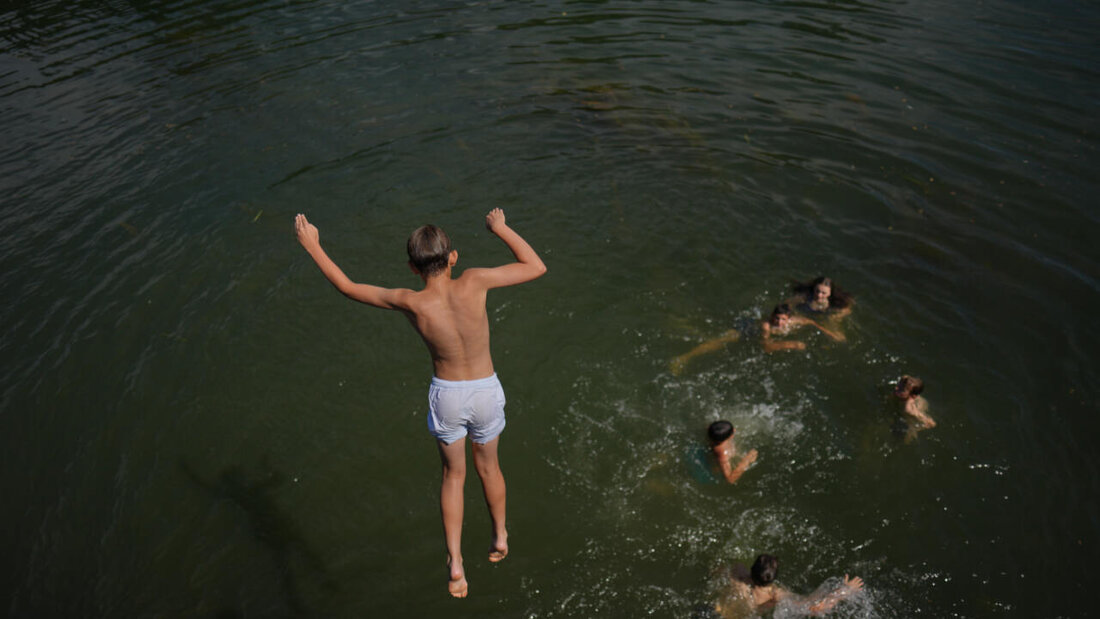 Ein Junge springt in die Seine. Foto: Thibault Camus/AP/dpa 20260620184731610.jpg