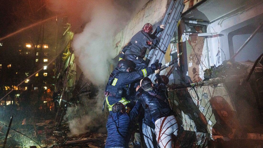 Rettungskräfte helfen einem verletzten Bewohner in Kiew über eine Leiter von seinem Balkon hinunter. Foto: Evgeniy Maloletka/AP/dpa 20261014045332573.jpg