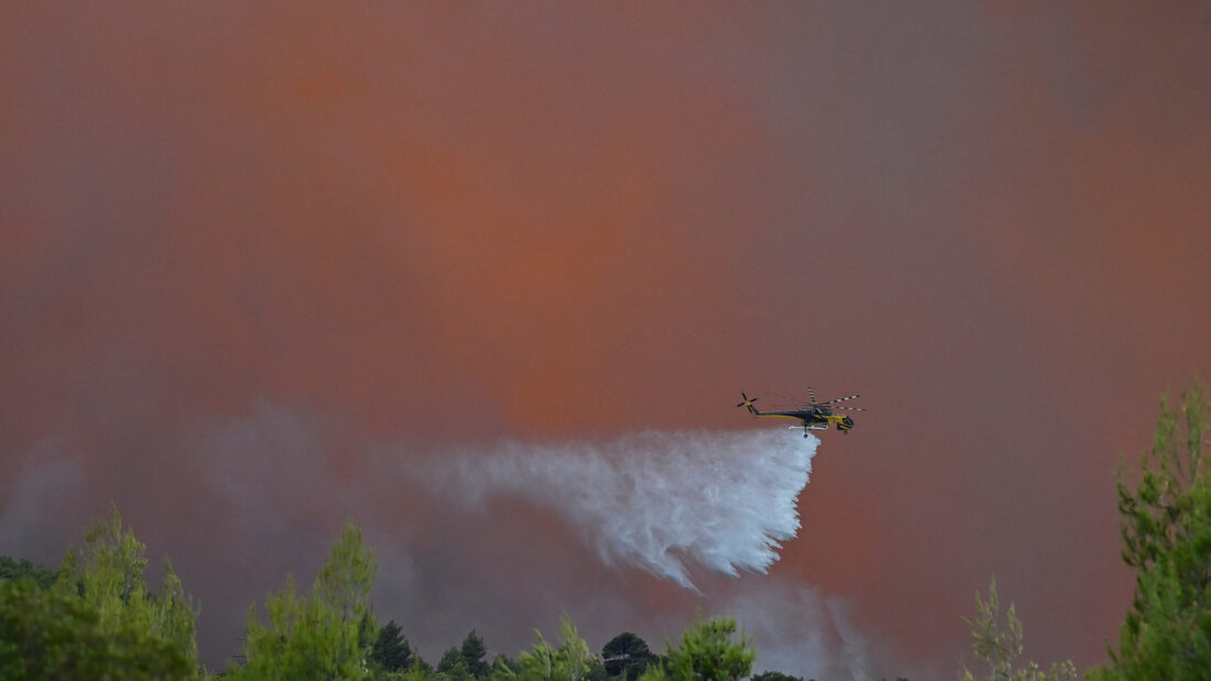 dpatopbilder - Ein Hubschrauber wirft nordwestlich von Athen während der Waldbrände Löschmittel ab. Foto: Michael Varaklas/AP/dpa 20260802193225920.jpg