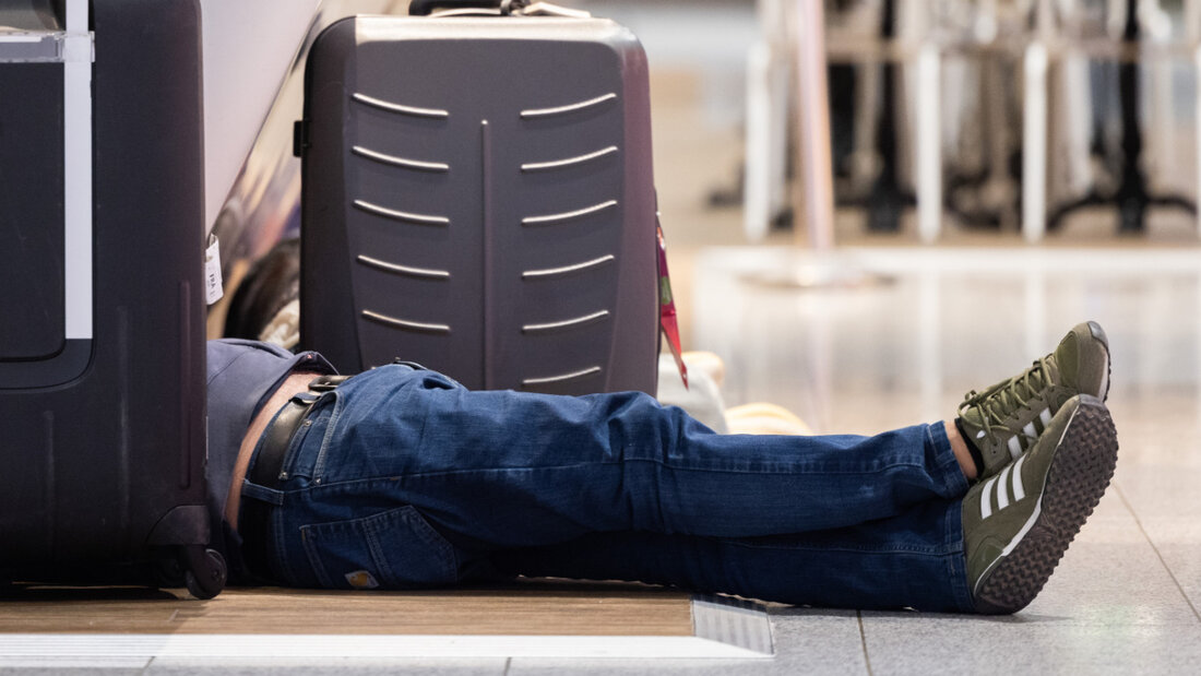 Ein Reisender schläft am Flughafen in Frankfurt zwischen seinem Gepäck. (Archivbild) 20250605175337277.jpg