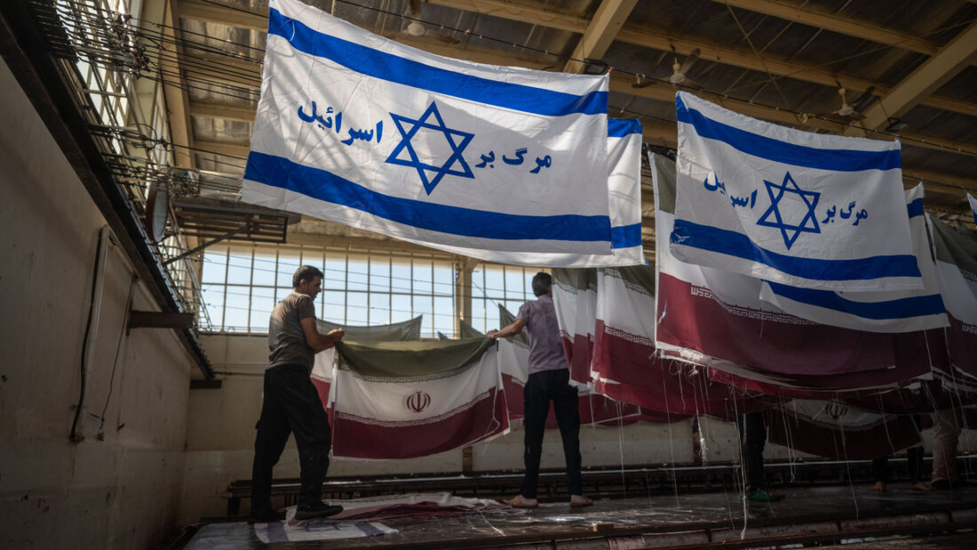 ARCHIV - Mitarbeiter einer Fabrik hängen Flaggen nach dem Trocknen ab. Foto: Arne Immanuel Bänsch/dpa 20250607150730233.jpg
