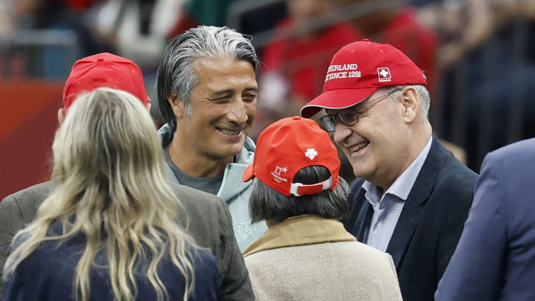 Der Schweizer Fussball-Nationaltrainer Murat Yakin schmunzelt vor dem Sechzehntelfinanspiel gegen Algerien - vielleicht wegen der Mütze von Bundespräsident Guy Parmelin neben ihm. 20260703074549165.jpg
