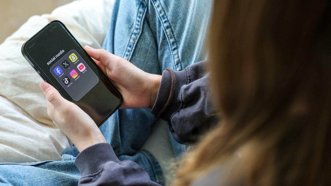 ILLUSTRATION - Ein Mädchen hält ein iPhone 16 in den Händen, auf dessen Display in einem Ordner mit der Bezeichnung "social media" die Logos von Facebook, X (ehemals Twitter), Snapchat, TikTok Pro, Instagram und YouTube zu sehen sind. Foto: Jan Woitas/dpa 20261012143059378.jpg