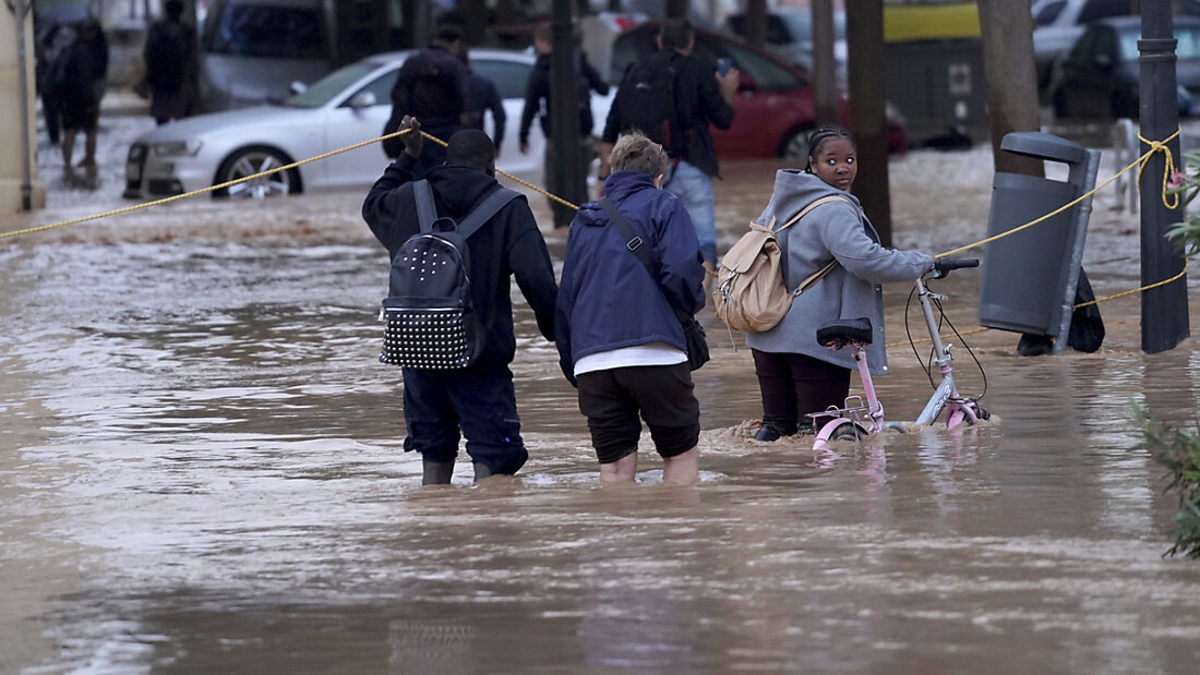 dpatopbilder - Menschen gehen durch überflutete Straßen in Valencia. Foto: ALberto Saiz/AP 20241030100408230.jpg