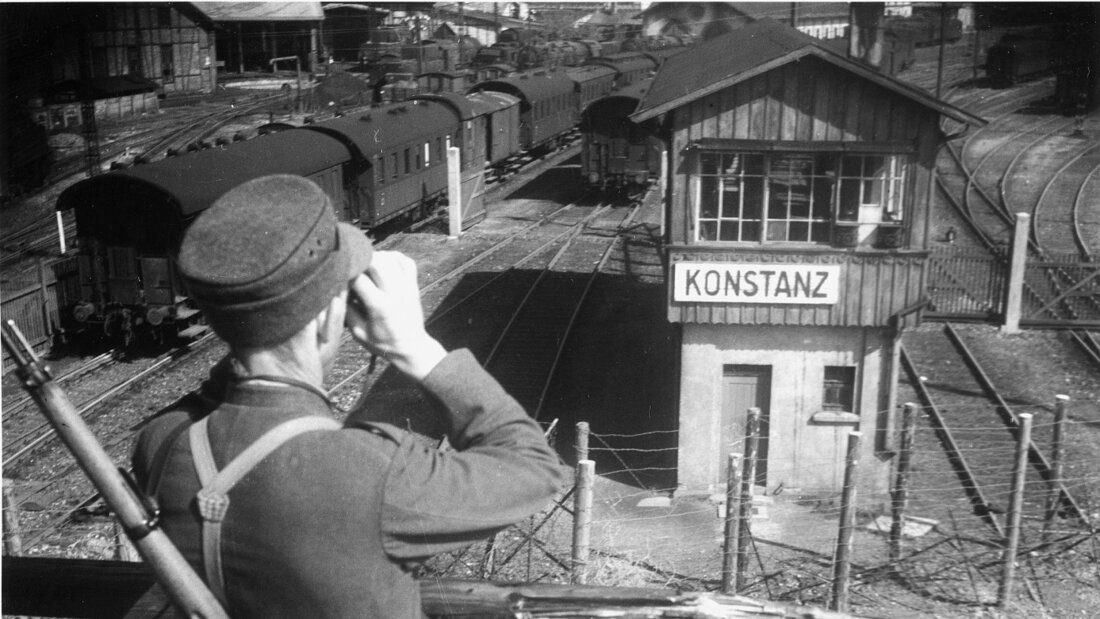Ein Schweizer Soldat beobachtet durch sein Fernglas den Bahnhof Konstanz D, aufgenommen gegen Ende des Zweiten Weltkriegs im April 1945. (Archivbild) 20260917150042576.jpg
