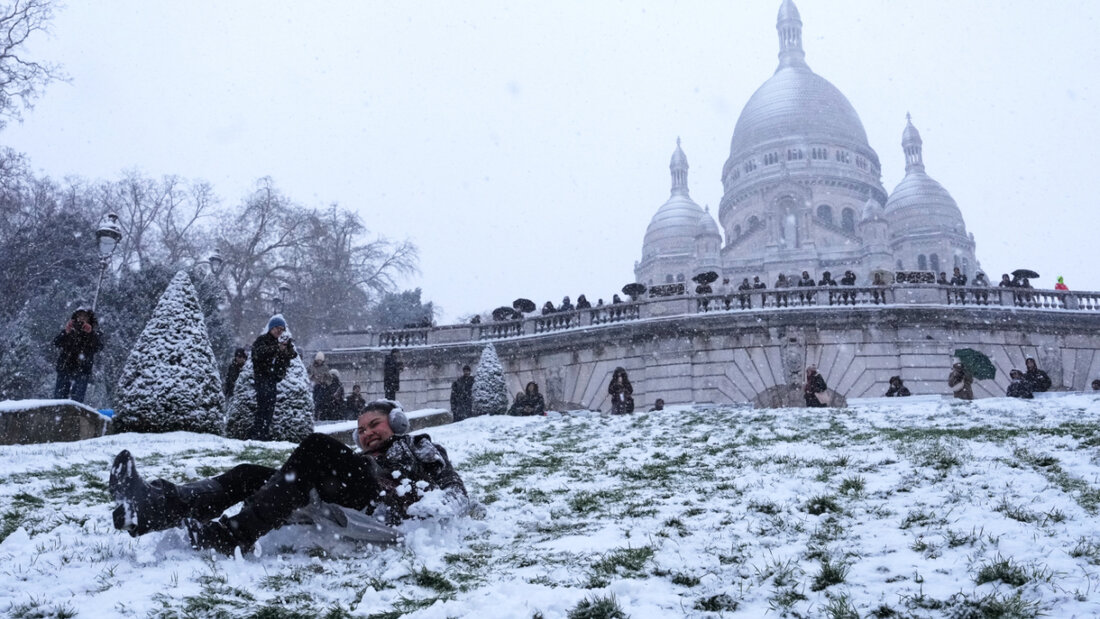 dpatopbilder - Menschen vergnügen sich im Schnee an einem Hang bei der Basilika Sacre-Coeur in Paris. Foto: Aurelien Morissard/AP/dpa 20260106114139878.jpg