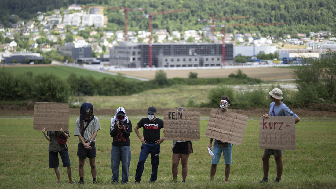 Die Aktivistinnen und Aktivisten traten am Freitag in Beringen SH vermummt vor die Medien. Im Hintergrund das im Bau befindliche Rechenzetrum, welches sie kritisierten. 20260703152858398.jpg