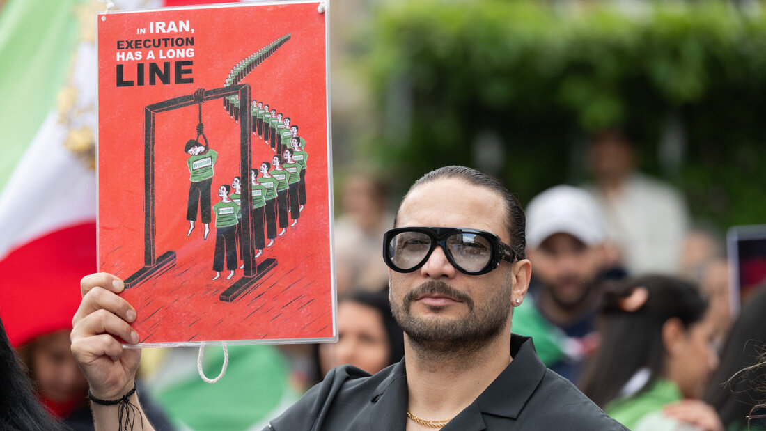 ARCHIV - Ein Mann trägt ein Schild mit der Aufschrift «In Iran, Execution has a long line». Mehrere hundert Menschen demonstrieren auf dem Rathenauplatz für den iranischen Oppositionspolitiker und Schah-Sohn Pahlavi. Auf Plakaten und in Sprechchören forderten sie ein Ende des islamischen Regimes im Iran. Foto: Boris Roessler/dpa 20260816102305633.jpg