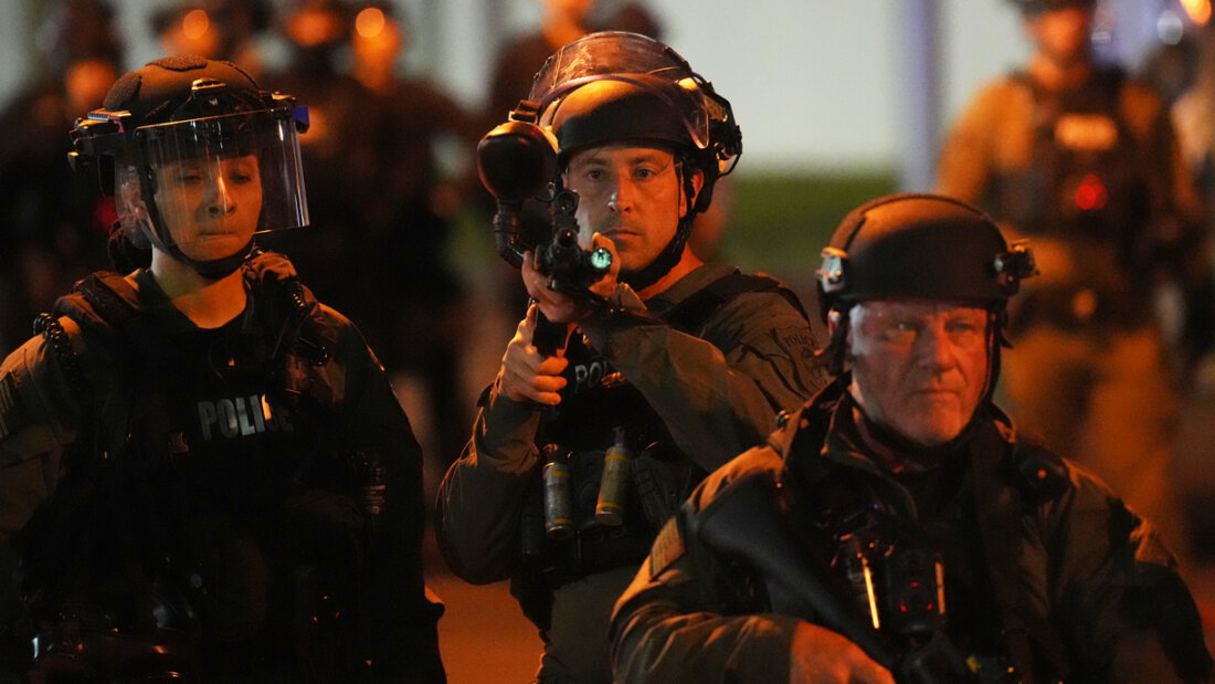 ARCHIV - Ein Beamter richtet seine Waffe auf Demonstranten vor dem Delaney Hall Detention Center in Newark, New Jersey. Die Vereinten Nationen zeigen sich angesichts der Zahl der Todesfälle im Gewahrsam der US-Einwanderungsbehörde alarmiert. Foto: Adam Gray/AP/dpa 20260626133955140.jpg