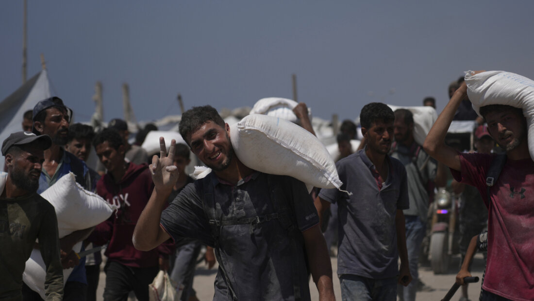 Palästinenser tragen Mehlsäcke, die von einem humanitären Hilfskonvoi abgeladen wurden. Foto: Abdel Kareem Hana/AP/dpa 20250727155913961.jpg