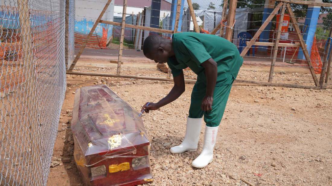 dpatopbilder - Ein Mitarbeiter des Bestattungsteams beschriftet im Behandlungszentrum des Allgemeinen Krankenhauses im Osten des Kongo einen Sarg. Knapp drei Monate nach Bekanntgabe des Ebola-Ausbruchs im Kongo sind bereits mehr als 2.000 Menschen gestorben. Foto: Dieudonne Dirole/AP/dpa 20260817131909784.jpg