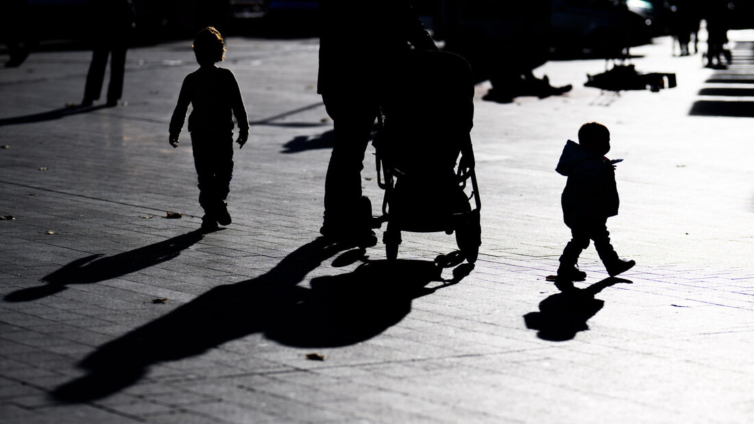 ARCHIV - Zwei Kinder und ein Mann mit einem Kinderwagen laufen im Gegenlicht der Sonne und werfen dabei lange Schatten auf den Boden. Foto: Julian Stratenschulte/dpa/Archivbild 20260831165905947.jpg