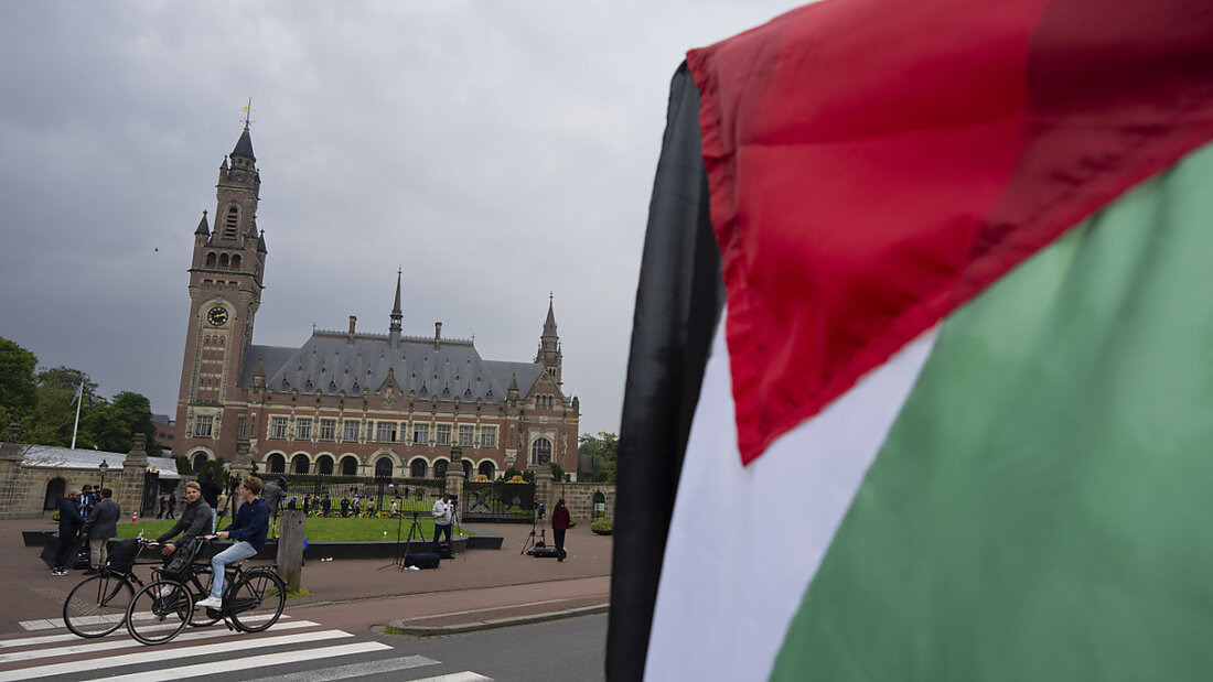 dpatopbilder - Ein Demonstrant schwenkt die palästinensische Fahne vor dem Friedenspalast, in dem der Internationale Gerichtshof untergebracht ist. Foto: Peter Dejong/AP/dpa 20240524201333031.jpg