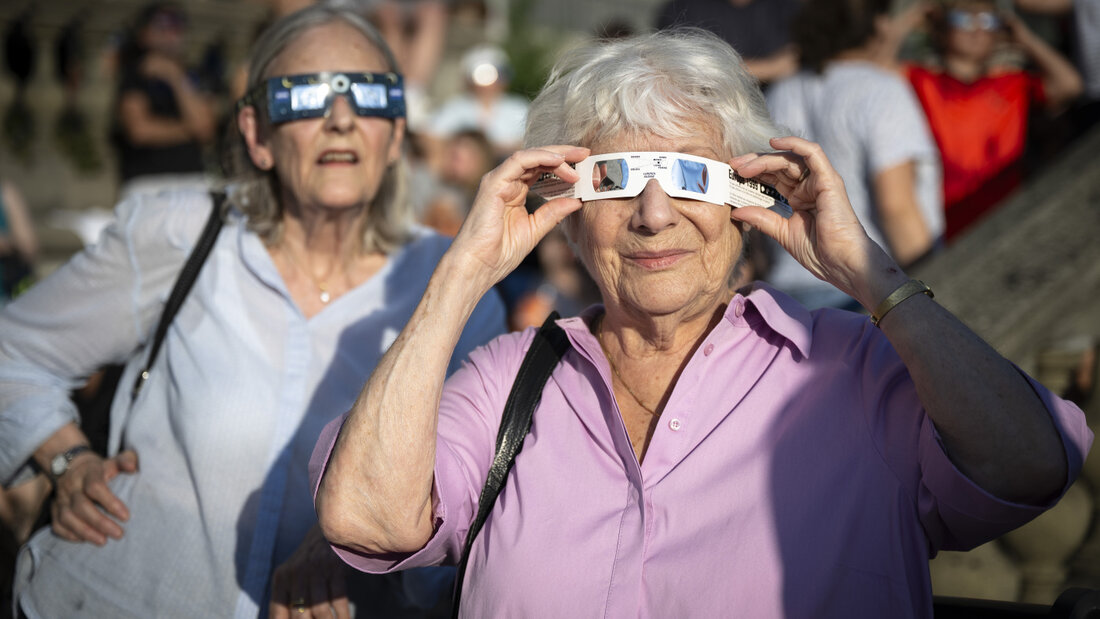 Zwei Frauen beobachten mit Schutzbrillen ausgerüstet am Mittwochabend auf der Zürcher Polyterrasse, wie der Mond die Sonne während der partiellen Sonnenfinsternis verdunkelt. 20260812195408315.jpg