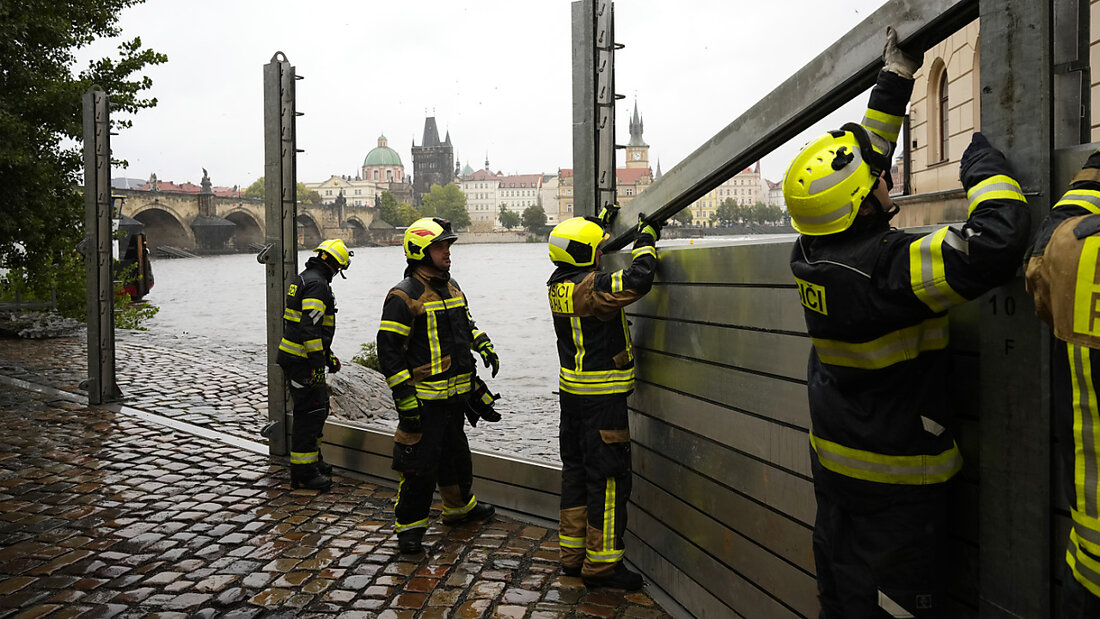 dpatopbilder - Feuerwehrleute stellen Teile einer Hochwasserschutzwände in Prag auf. Foto: Petr David Josek/AP 20240914071046123.jpg