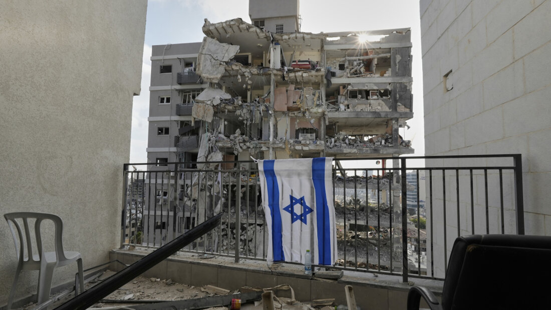 dpatopbilder - Eine israelische Flagge hängt am Balkongeländer eines der Wohnhäuser, die durch einen iranischen Raketenangriff zerstört wurden. Foto: Baz Ratner/AP/dpa 20250615201042378.jpg
