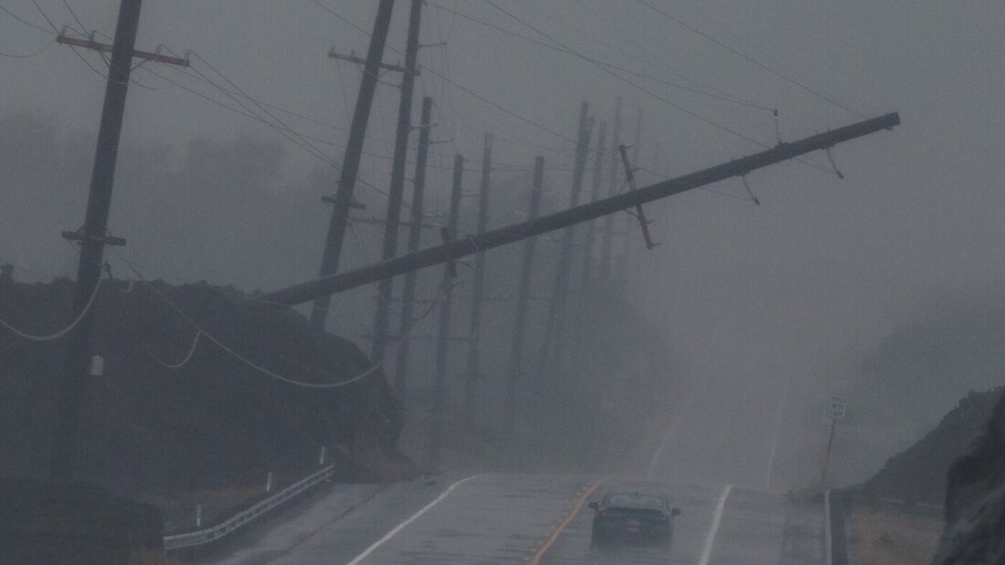 dpatopbilder - Ein Fahrzeug fährt in der Nähe von Ocean View während des Hurrikans «Lala» an einem umgestürzten Strommast vorbei, der über dem Mamalahoa Highway hängt. Foto: Stephen Lam/San Francisco Chronicle/AP/dpa 20260816112332317.jpg